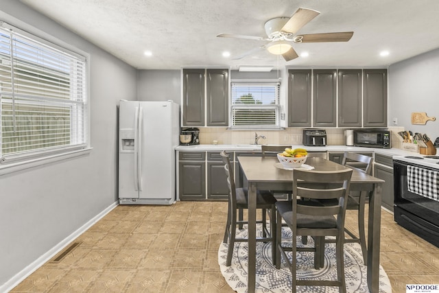kitchen featuring visible vents, white refrigerator with ice dispenser, recessed lighting, gray cabinets, and electric range oven