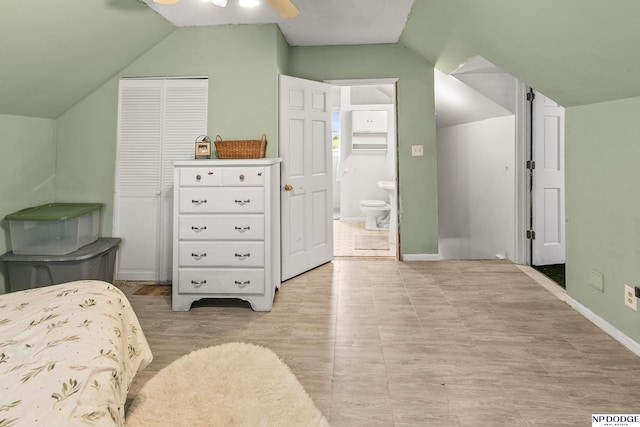 bedroom with connected bathroom, ceiling fan, baseboards, lofted ceiling, and a closet