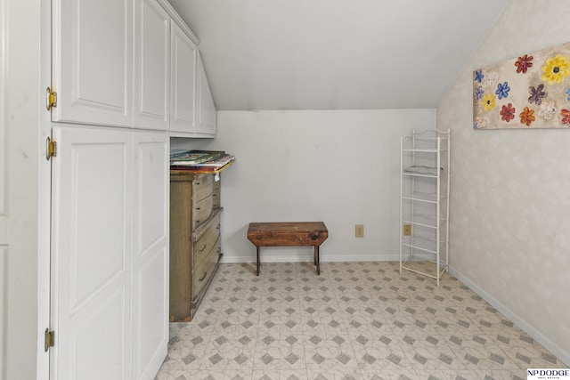 interior space with light floors and vaulted ceiling