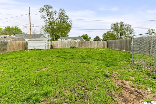 view of yard featuring an outdoor structure, a shed, and a fenced backyard