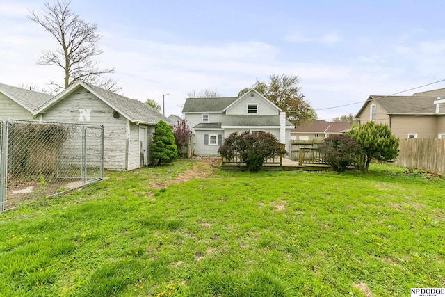view of yard featuring fence, a wooden deck, and an outdoor structure