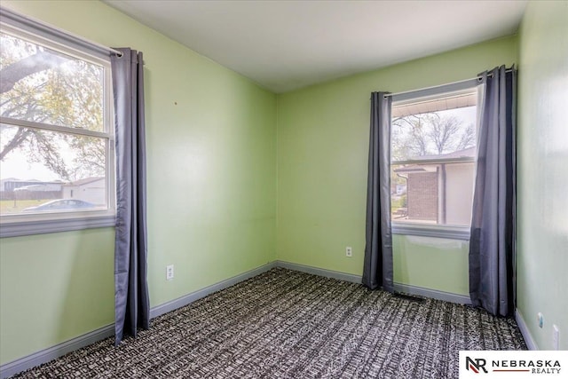 spare room featuring carpet flooring and baseboards