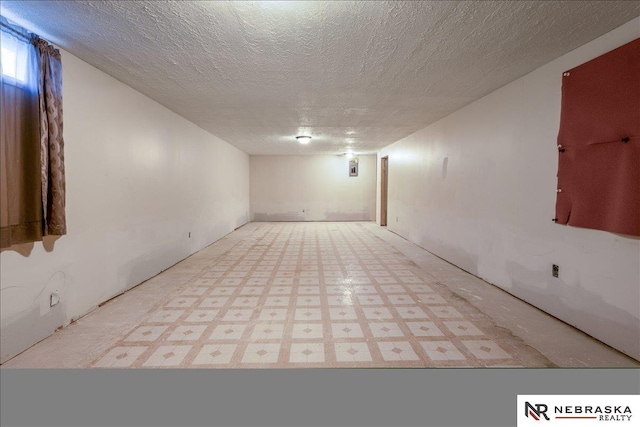 empty room featuring a textured ceiling and tile patterned floors