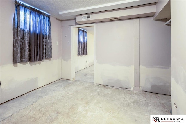 unfurnished bedroom with visible vents, a closet, and unfinished concrete floors