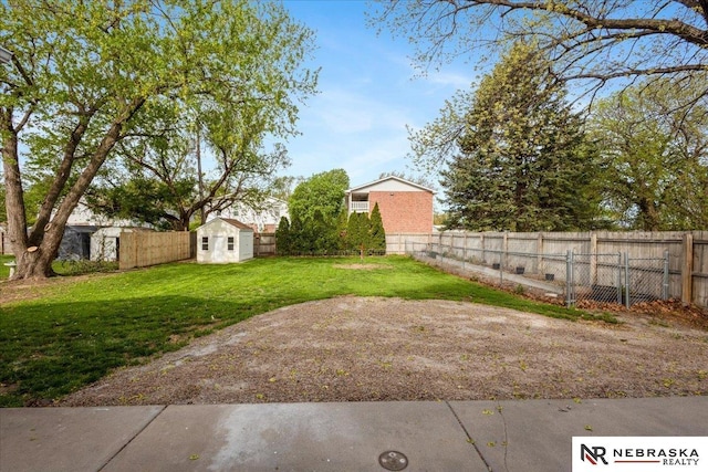 view of yard with an outbuilding, a fenced backyard, and a storage unit