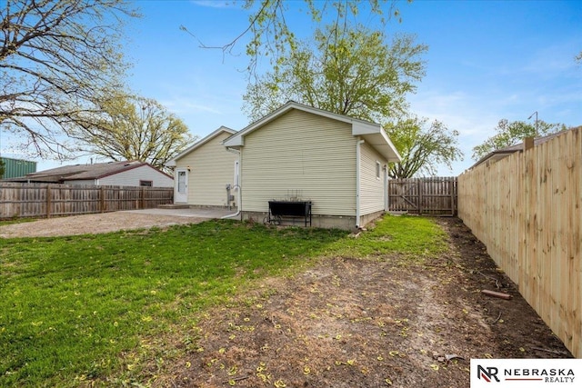 rear view of property with a lawn, a fenced backyard, and a patio