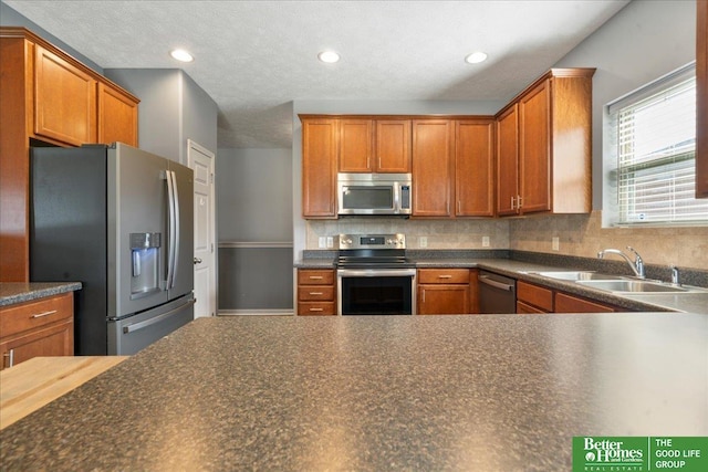 7714 S 167th St, Omaha, NE 68136 - kitchen featuring decorative backsplash, dark countertops, a sink, stainless steel appliances, and recessed lighting