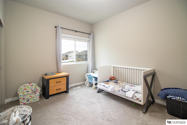 bedroom with light colored carpet and baseboards