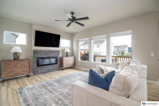 living room with a ceiling fan, baseboards, a healthy amount of sunlight, and wood finished floors