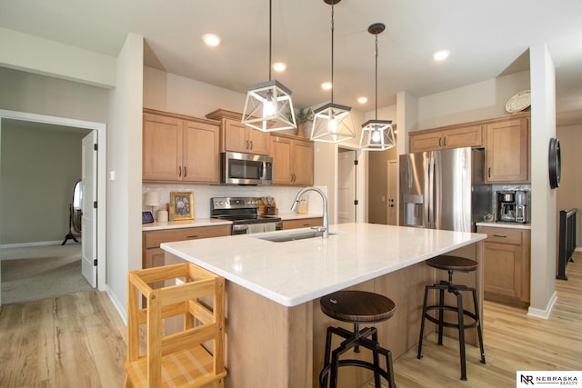kitchen featuring a sink, a kitchen breakfast bar, backsplash, and stainless steel appliances