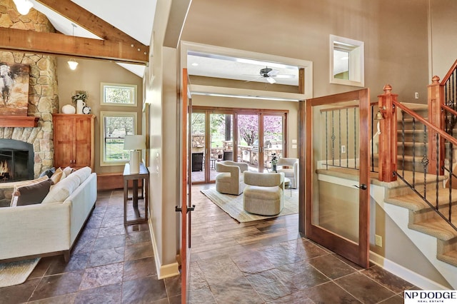 living area featuring plenty of natural light, a fireplace, french doors, and stone tile flooring