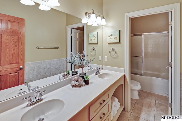 bathroom featuring a sink, tile patterned flooring, toilet, and double vanity