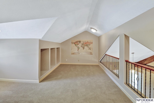 bonus room with carpet floors, baseboards, and vaulted ceiling