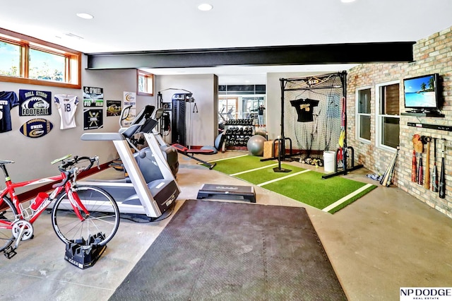 workout area featuring recessed lighting and brick wall