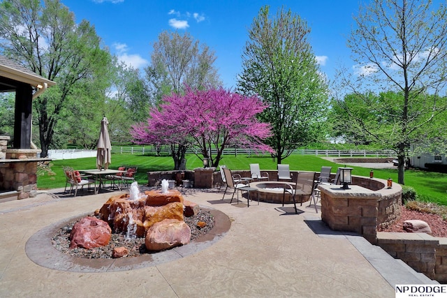 view of patio featuring outdoor dining area, an outdoor fire pit, and fence