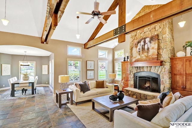 living room featuring baseboards, high vaulted ceiling, and stone tile floors