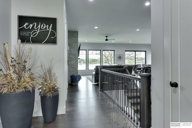 corridor featuring recessed lighting, wood finished floors, and an upstairs landing