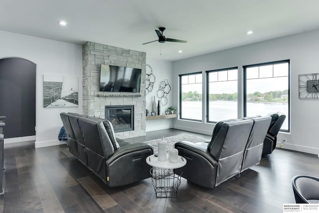 living area featuring a ceiling fan, baseboards, recessed lighting, and a stone fireplace