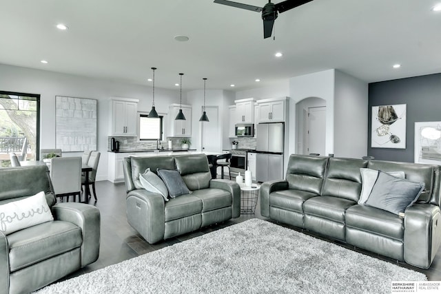 living room featuring recessed lighting, ceiling fan, and arched walkways