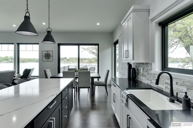 kitchen featuring white cabinets, a sink, recessed lighting, decorative backsplash, and pendant lighting