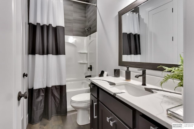 bathroom featuring toilet, wood finished floors, shower / bath combo, and vanity