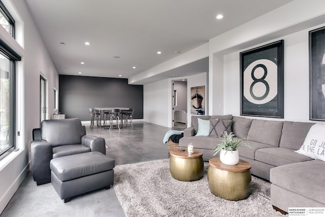 living room with baseboards, recessed lighting, and concrete flooring