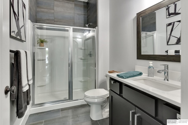 full bath with vanity, a shower stall, and toilet