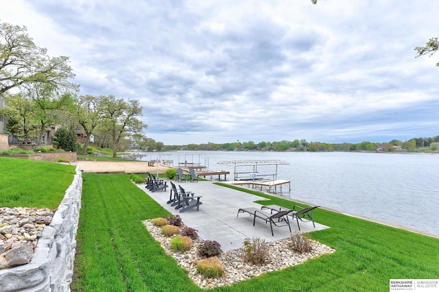 view of dock with a lawn and a water view