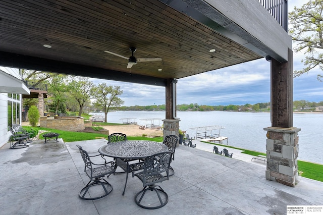 view of patio with outdoor dining area, a water view, and ceiling fan