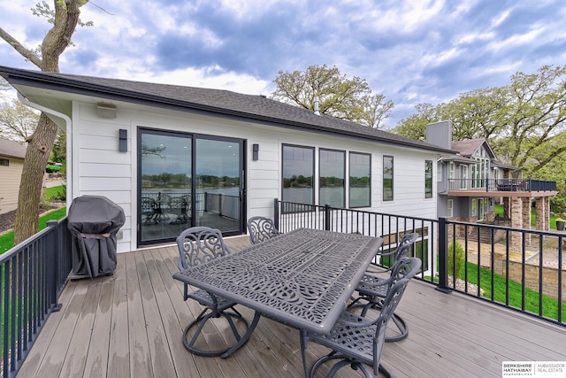 deck featuring outdoor dining area and a grill