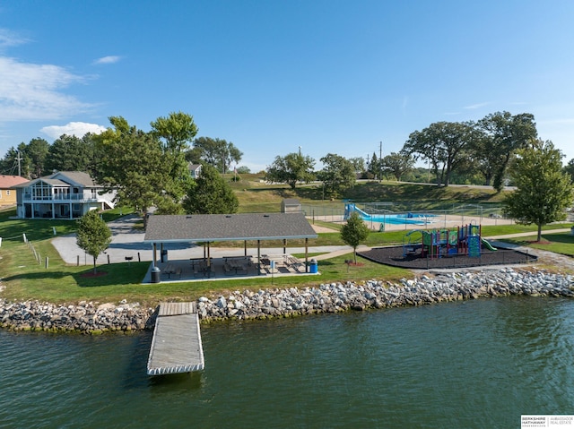 dock area with a gazebo, a water view, a lawn, and playground community