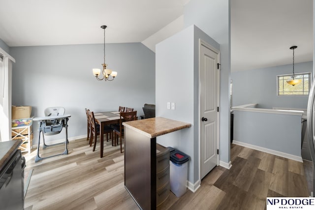 dining area with baseboards, a chandelier, wood finished floors, and lofted ceiling