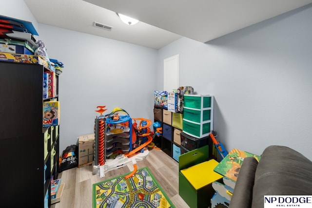 recreation room featuring visible vents and wood finished floors