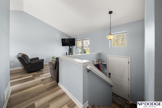 stairway featuring vaulted ceiling and wood finished floors