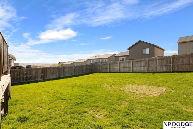 view of yard with a fenced backyard and a residential view