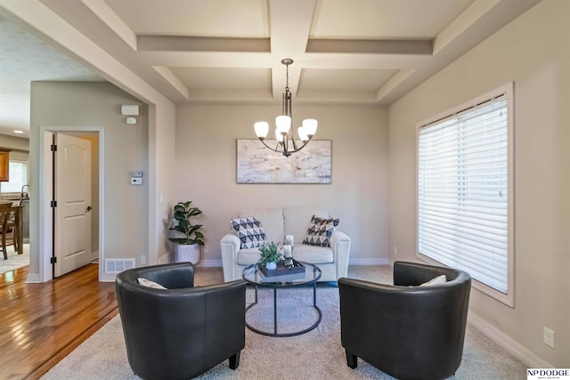 sitting room with visible vents, baseboards, beamed ceiling, an inviting chandelier, and coffered ceiling