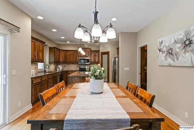 dining room featuring recessed lighting, baseboards, a notable chandelier, and light wood finished floors