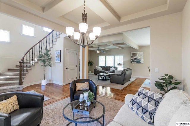 living area featuring plenty of natural light, wood finished floors, stairway, and coffered ceiling