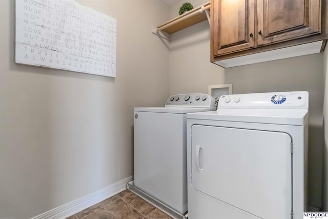 washroom featuring baseboards, cabinet space, and washer and dryer