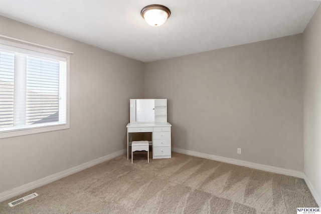 unfurnished bedroom featuring visible vents, baseboards, and light colored carpet