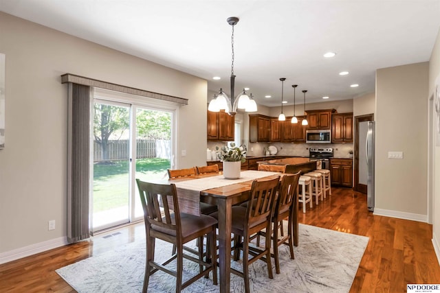 dining room with recessed lighting, baseboards, an inviting chandelier, and dark wood-style floors