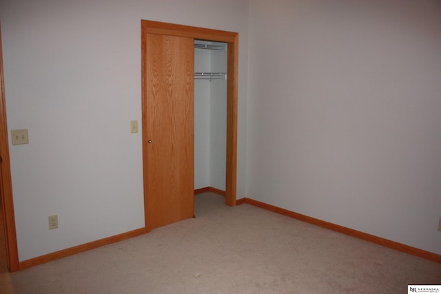 unfurnished bedroom featuring carpet floors, baseboards, and a closet