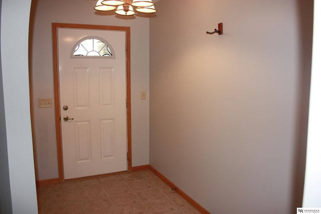 doorway featuring light tile patterned floors and baseboards