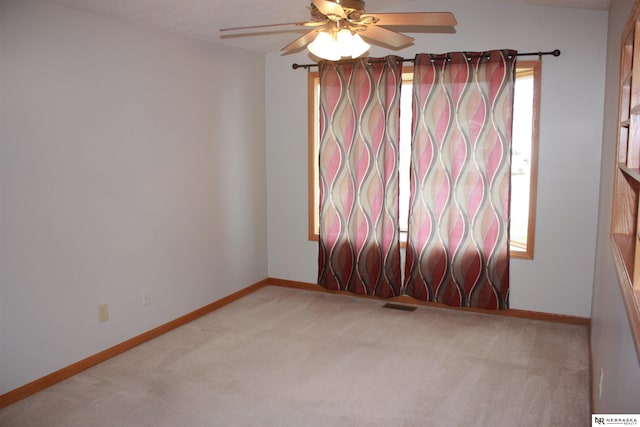 carpeted empty room featuring a ceiling fan, baseboards, and visible vents