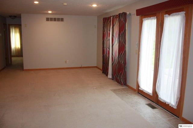 unfurnished room with recessed lighting, light colored carpet, visible vents, and baseboards