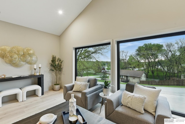 living room with high vaulted ceiling, baseboards, recessed lighting, and wood finished floors