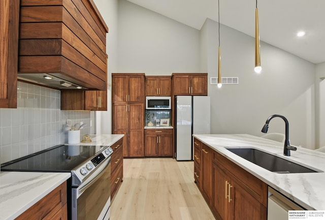 kitchen featuring electric range, a sink, freestanding refrigerator, lofted ceiling, and custom range hood