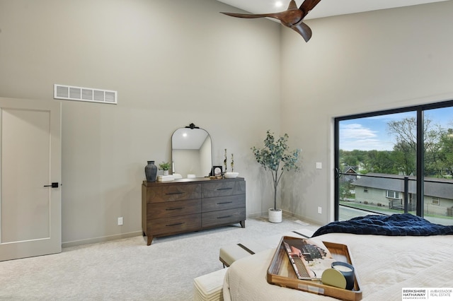 carpeted bedroom with a ceiling fan, a towering ceiling, visible vents, baseboards, and access to outside