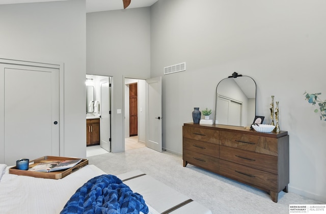 bedroom with visible vents, baseboards, ensuite bath, and high vaulted ceiling