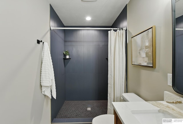 full bathroom featuring toilet, recessed lighting, tiled shower, and vanity